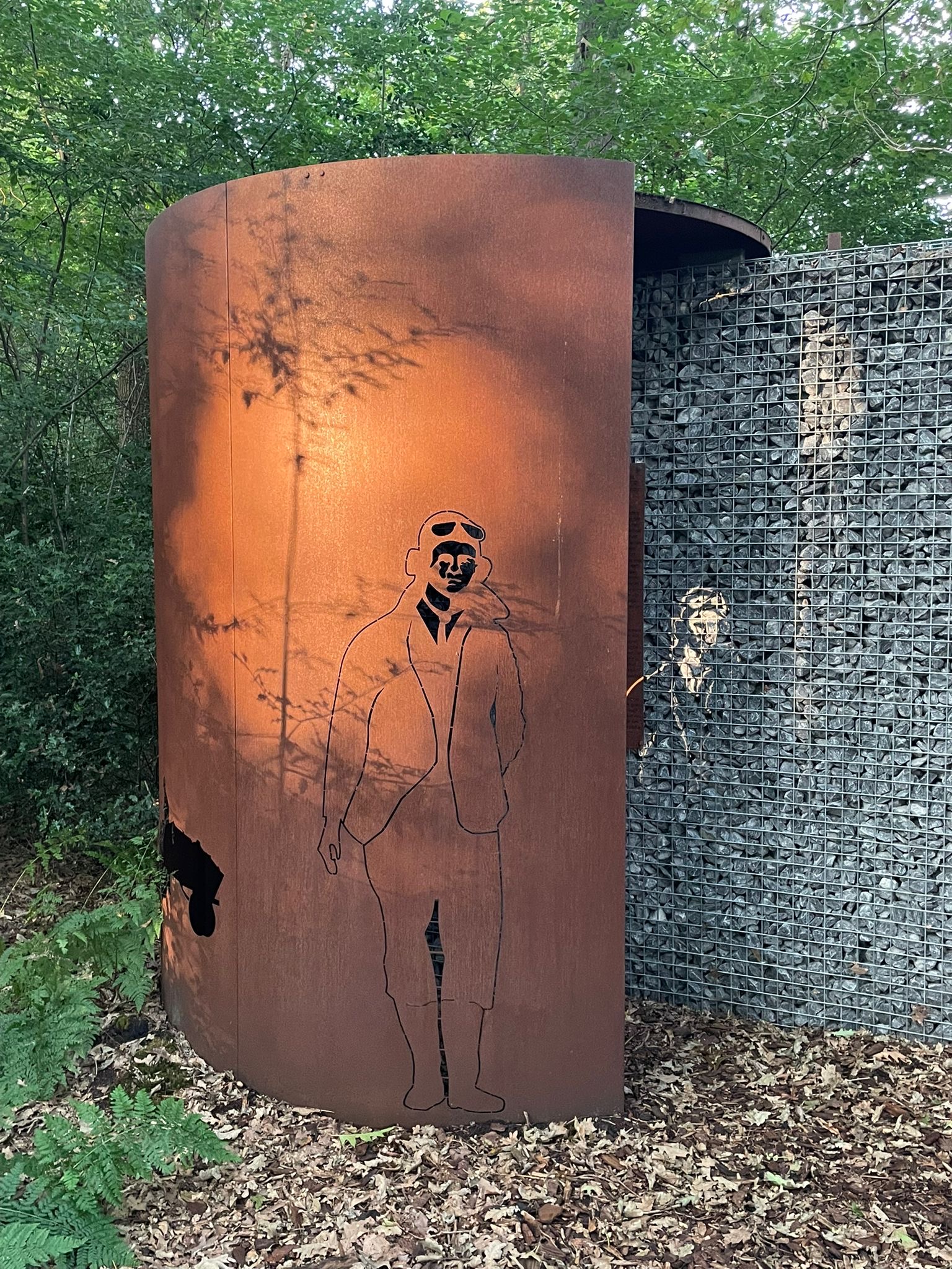 Het silhouet van Samuel J. Melancon op de cortenstalen cilinder